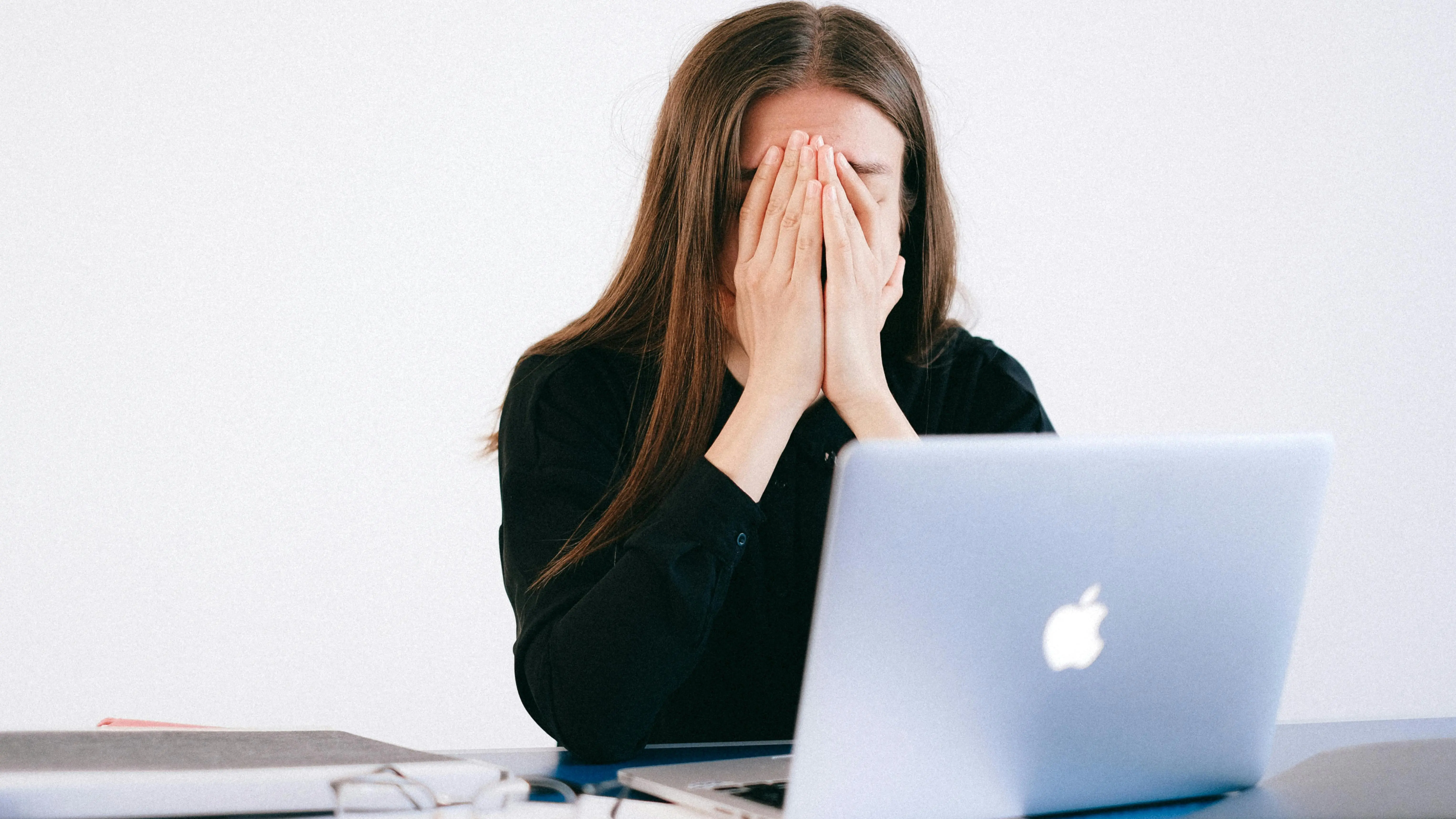 Woman contemplating how to write a screenplay with heart in front of a laptop