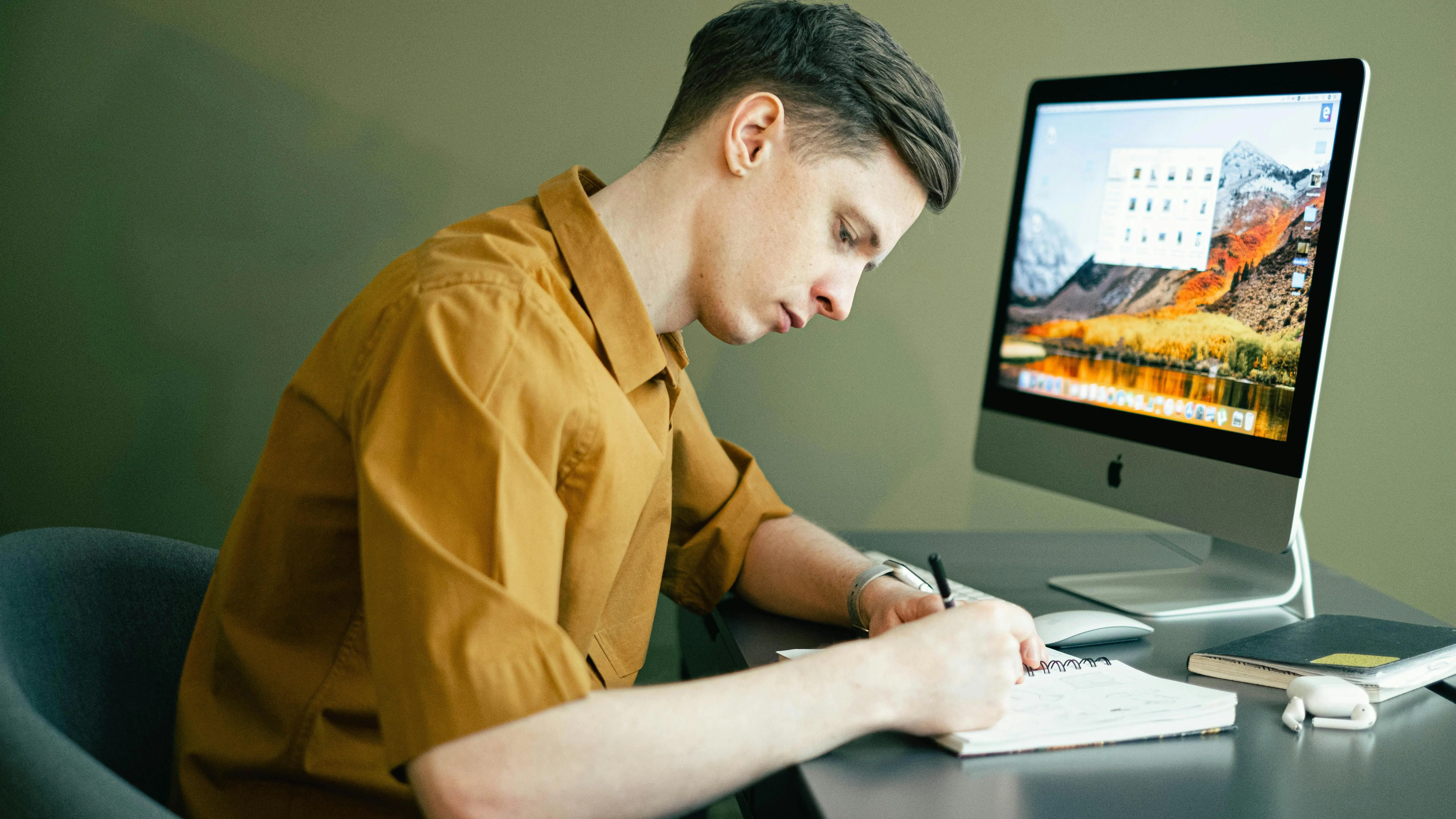 Man taking notes in front of computer brainstorming a TV show idea