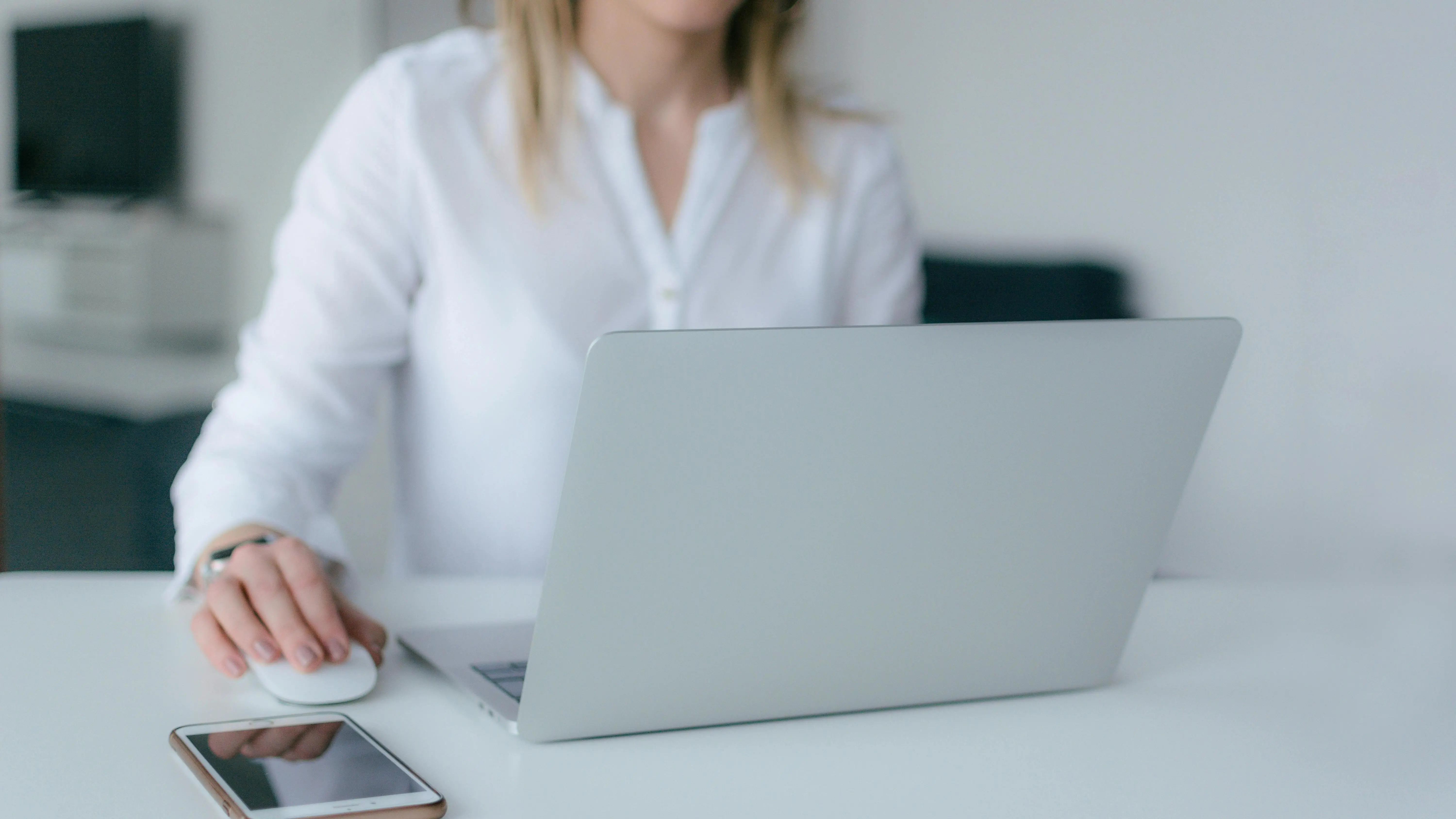 Woman writing on a silver laptop while starting your screenplay