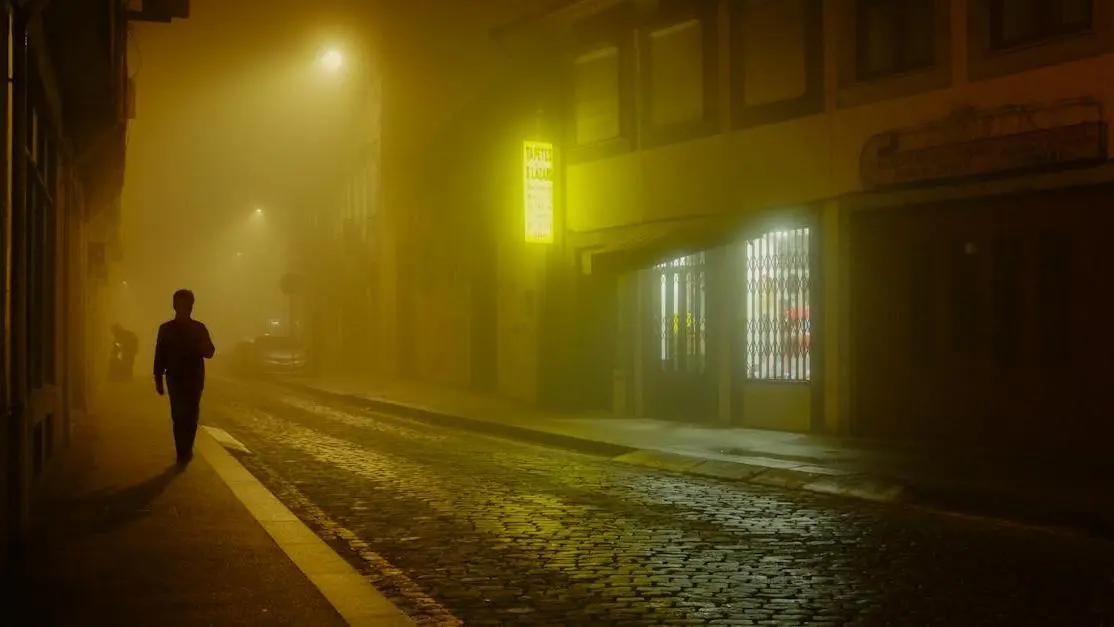 Mysterious figure walking under streetlights, emphasizing thriller screenplays theme.
