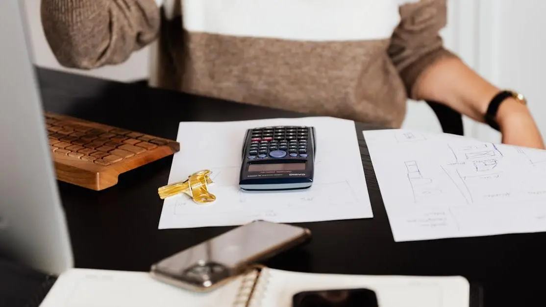 Calculator on top of screenplay budgeting worksheet.