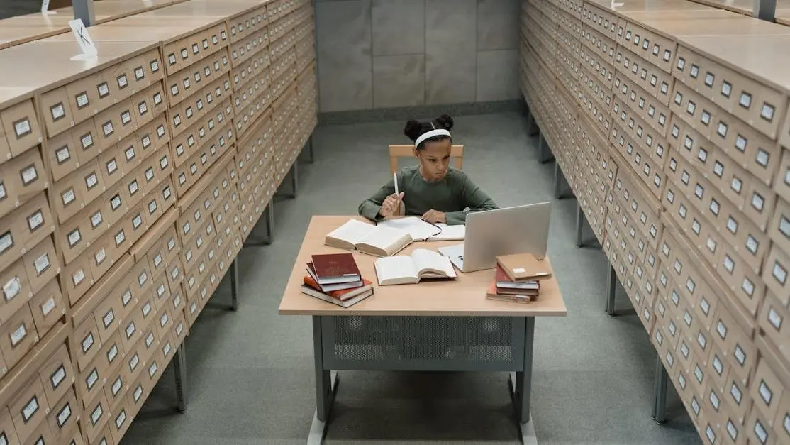 Student researching in a historic library, laptop and books; writing one hour TV pilots tips focus