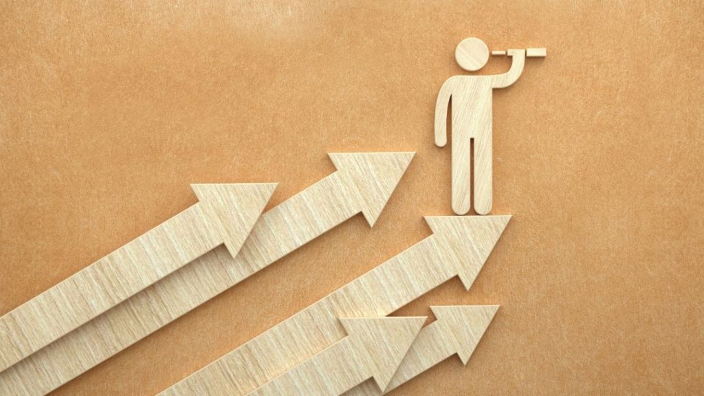Minimalist wooden figure standing atop upward-pointing arrows with a telescope, representing a step-by-step screenwriting career guide and long-term industry roadmap for 2026.