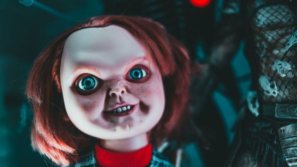 Close-up of the creepy Chucky doll from the Child's Play horror franchise, representing key horror tropes evaluated by script coverage analysis.